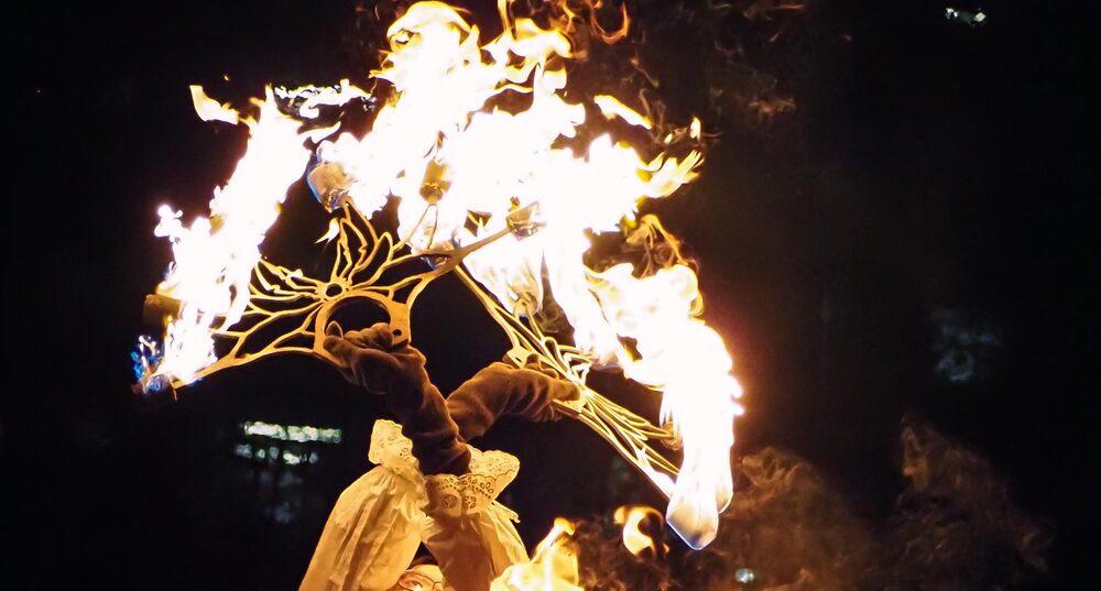 Firespinner raising Flaming PyroFox Custom Fire Fans with unique wavy design above their head